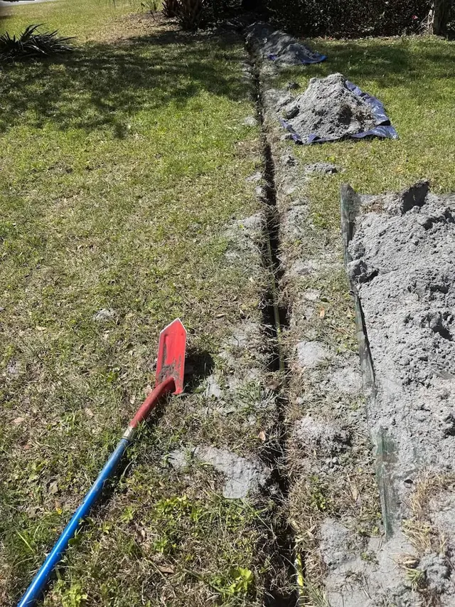 Long water line trench cut across a residential lawn